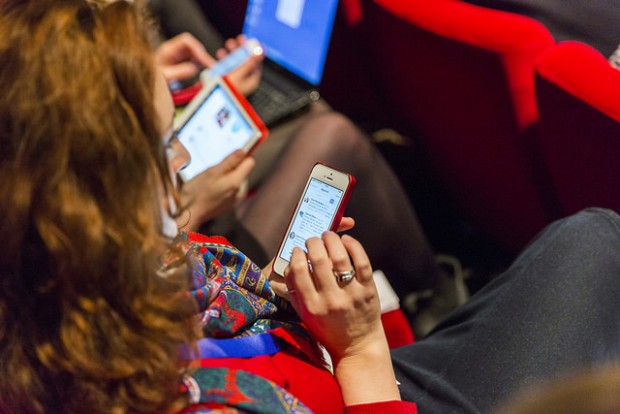 Members of the audience using smartphones at an event