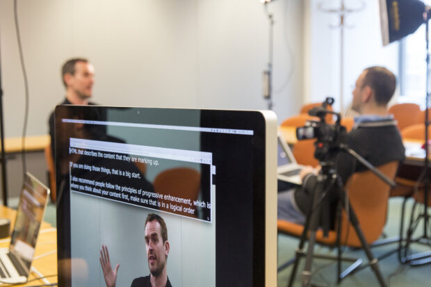 Giles interviewing Alistair with a display of the live transcription at the top of the screen and a video of Alistair at the bottom